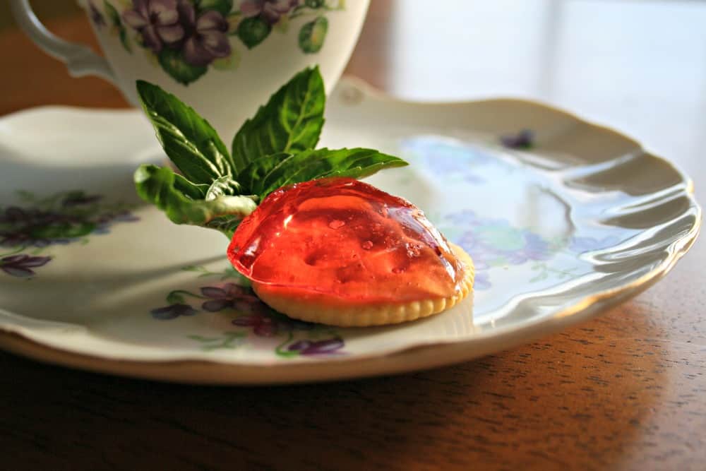 basil cranberry herb jelly on a cracker on a plate