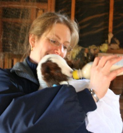 Jeanne feeding a baby goat with a bottle