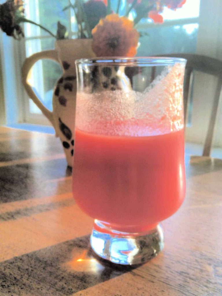 a glass of tomato juice on a wooden table