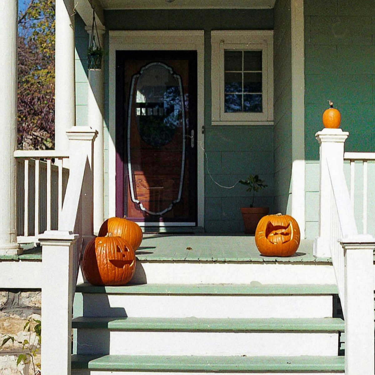 carved pumpkins on the steps and porch of a house