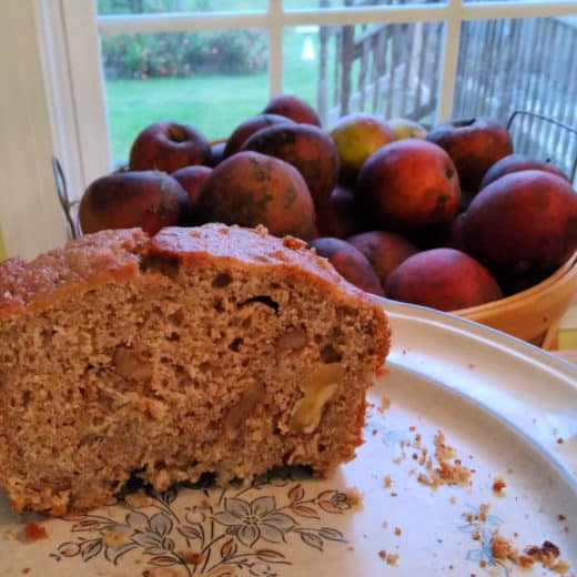 walnut applesauce bread with apples in the background
