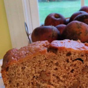 walnut applesauce bread with apples in the background