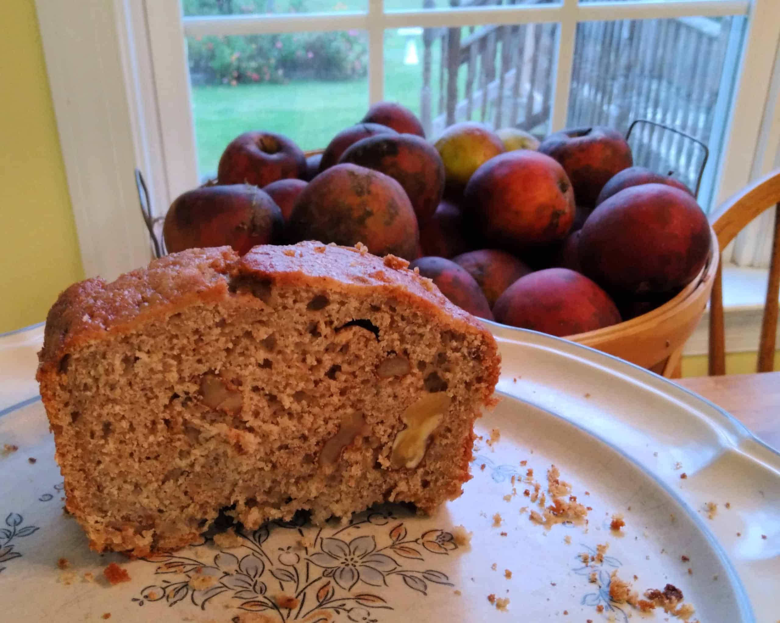 walnut applesauce bread with apples in the background