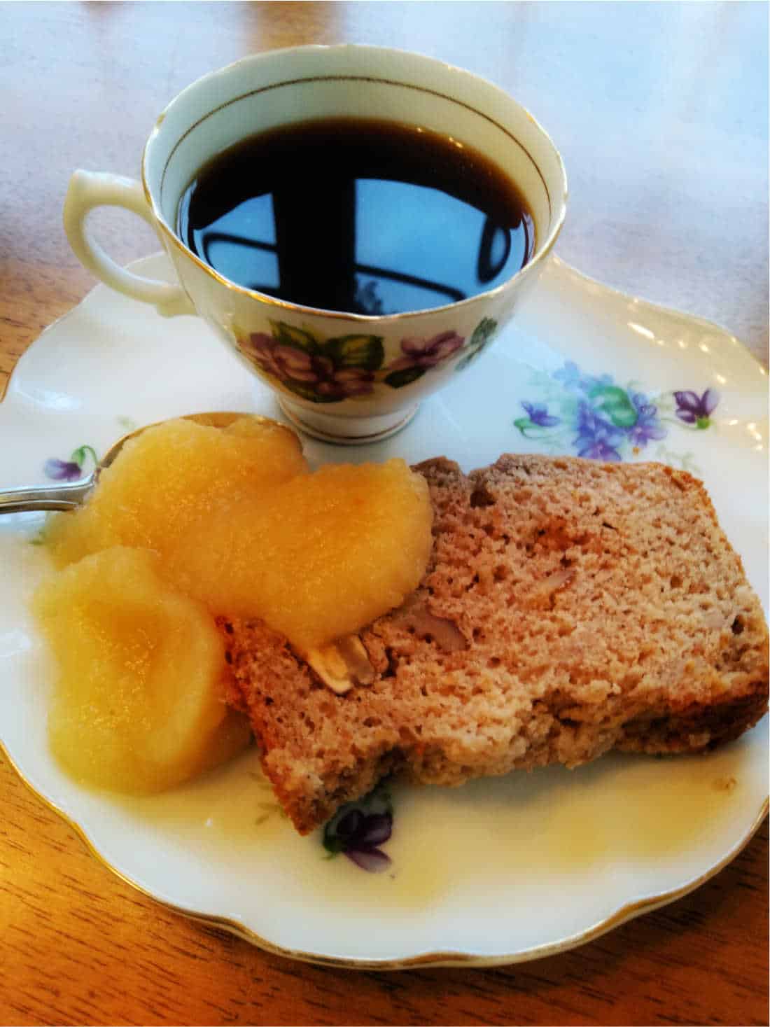 walnut applesauce bread on a plate with coffee