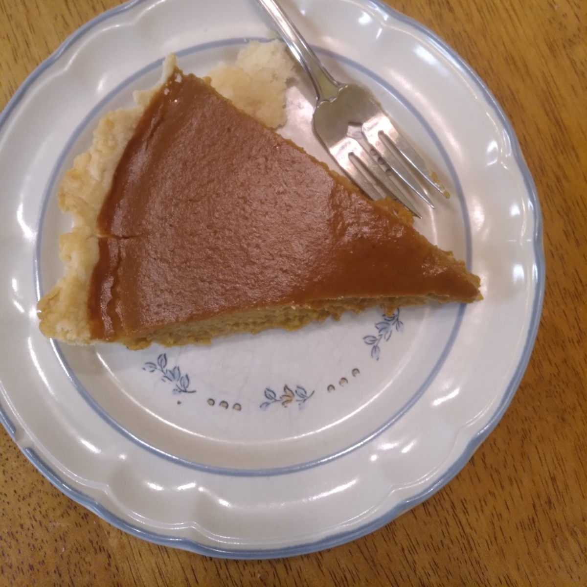 a slice of pumpkin pie on a plate with a fork